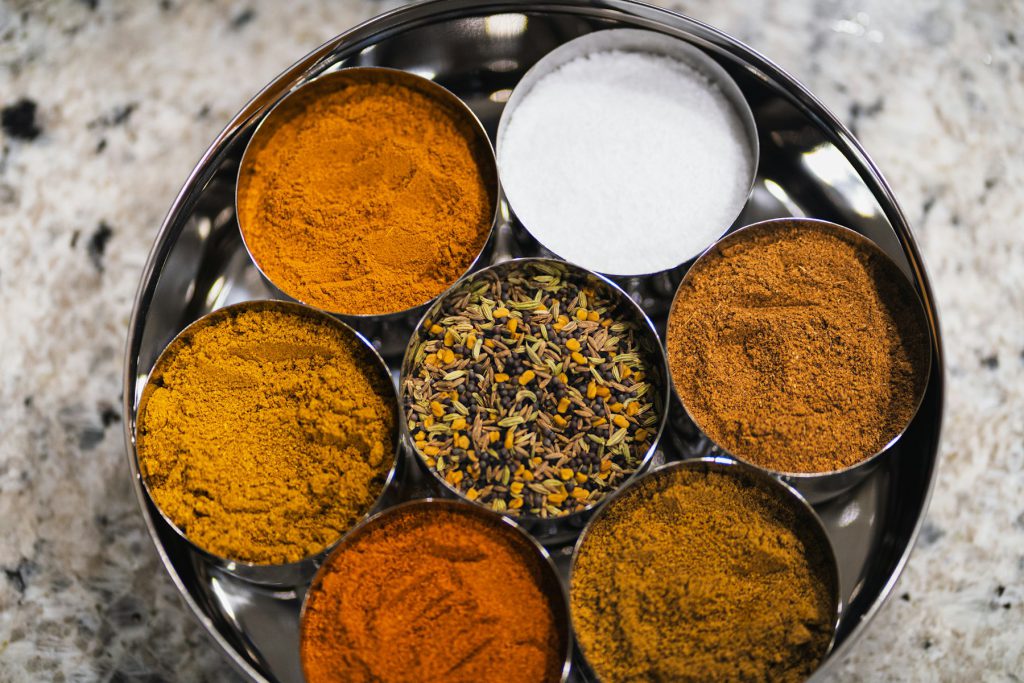 Indian spices in metal bowls on a tray
