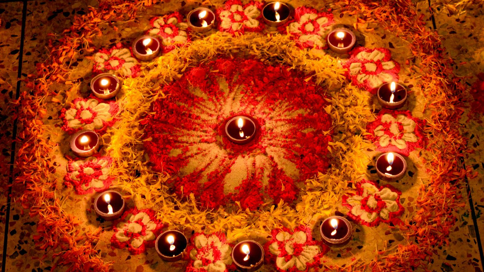 Rangoli surrounded by lit diyas